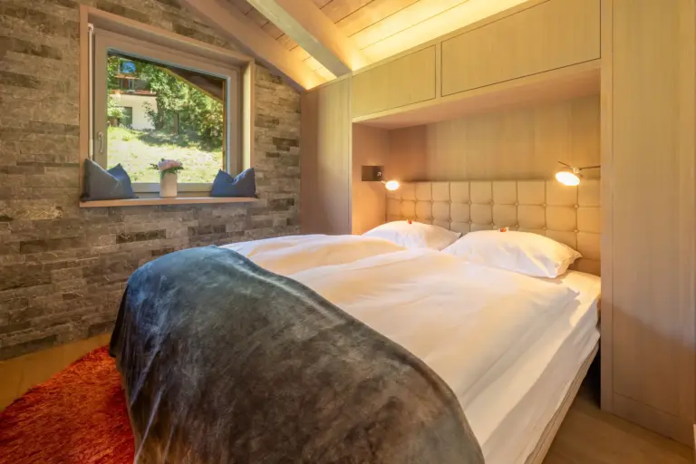 haus-hiltl-zermatt-schlafzimmer-doppelbett-holzwand