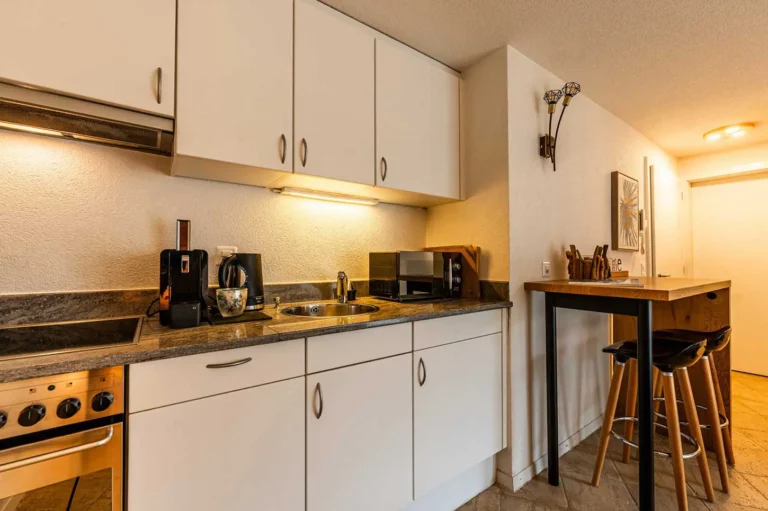 a kitchen with white cabinets and a table