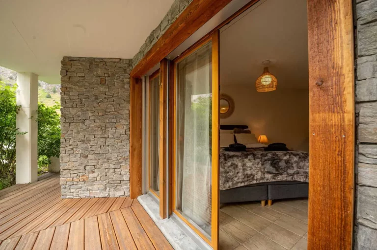 a bedroom with a stone wall and a wood deck